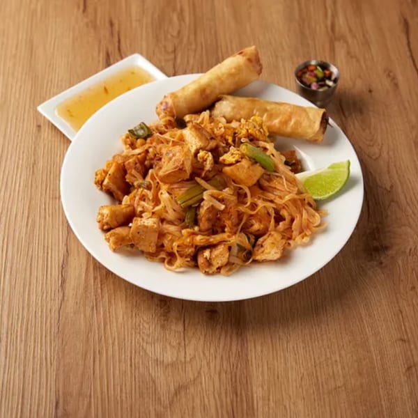 Lantern's Pad Thai with tofu, noodles, green onions, egg rolls, lime, and dipping sauces.